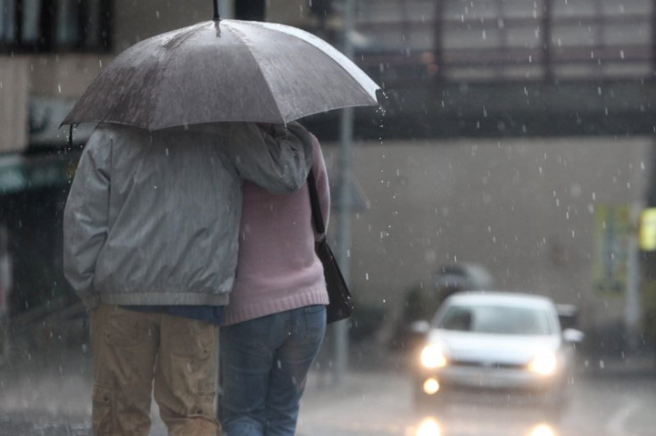 Una parella passeja amb un paraigües pel carrer.