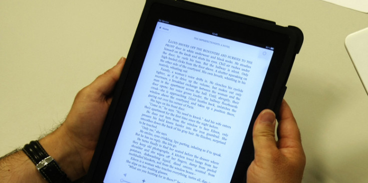 Un usuari d'iPad llegint un text en una tauleta