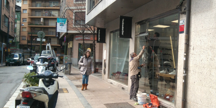 Un operari intenta treure la porta trencada de l'establiment TheSneakerOne, ahir a Andorra la Vella.