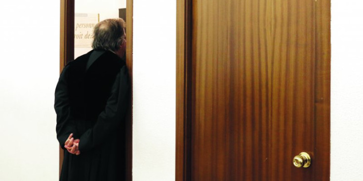 Un advocat espera a la porta dels despatxos dels lletrats a la Seu de la Justícia.