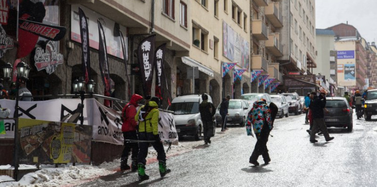 Diversos turistes en un dels carrers centrals del Pas de la Casa, on han acudit per anar a esquiar.