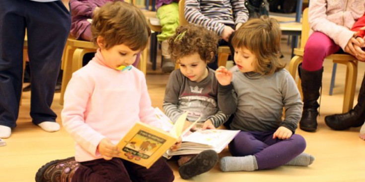 Tres infants llegeixen un conte a la Bilblioteca d’Encamp.