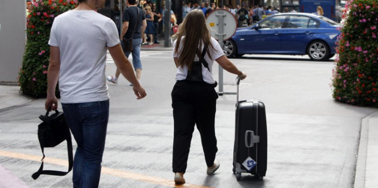 Una turista passeja amb una maleta al centre d’Escaldes-Engordany.