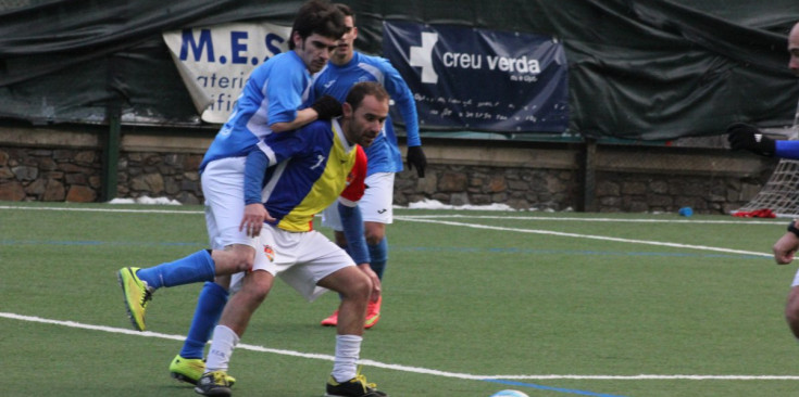 Juli Sánchez defensa la pilota amb un jugador de l’Alcarràs a sobre.