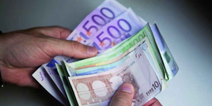 Una persona compta diners en bitllets d’euro.