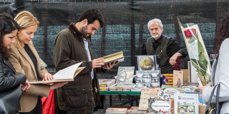 Diverses persones fullegen llibres ahir a la plaça del Poble d’Andorra la Vella.