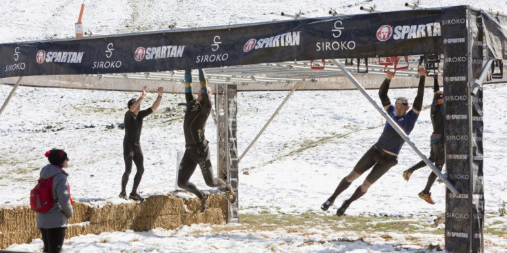 Els participants superen un obstacle de l’Spartan Race de l’any passat celebrada a Encamp en un ambient nevat.