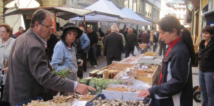 Diversos clients compren a les parades del mercat setmanal de la Seu.