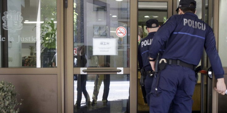 Dos agents de la policia entren a l’edifici de la Seu de la Justícia, a l’avinguda Tarragona d’Andorra la Vella.
