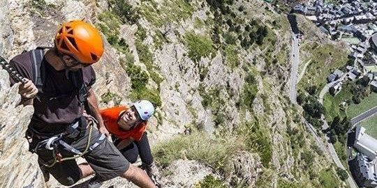 Dos escaladors pugen la via ferrada del Roc del Quer, a Canillo.