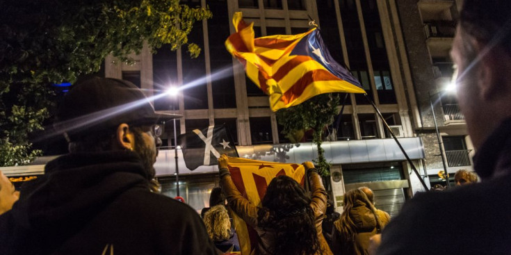 Diverses persones amb estelades criden davant de l’Ambaixada espanyola, ahir.