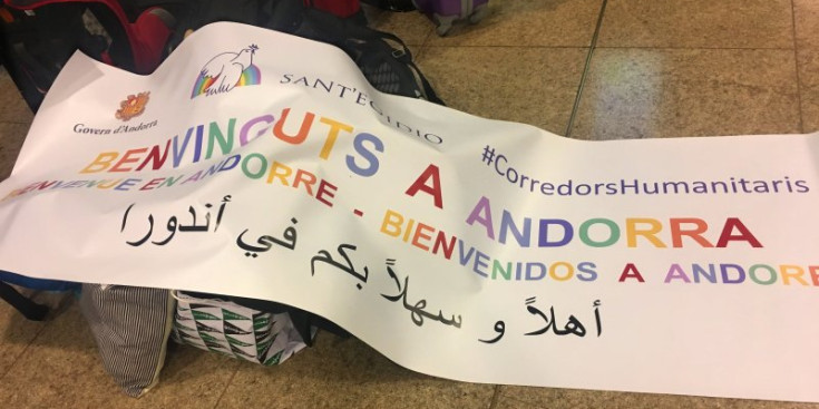 La pancarta conjunta de benvinguda del Govern d’Andorra i la Comunitat de Sant Egidi, ahir a l’Aeroport del Prat.