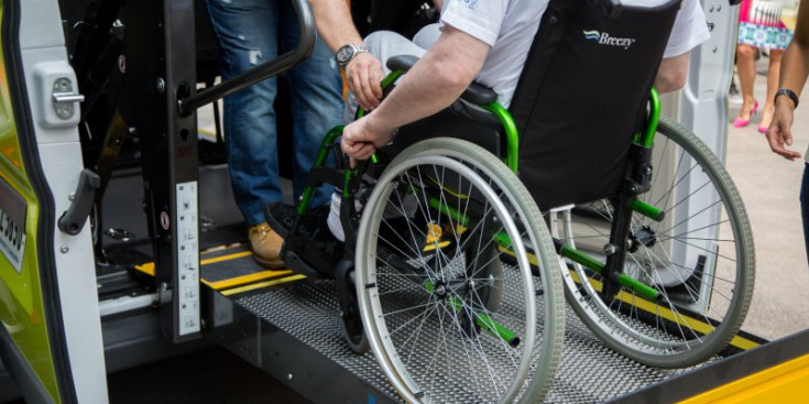 Un home amb mobilitat reduïda accedeix a un vehicle adaptat a les persones minusvàlides.
