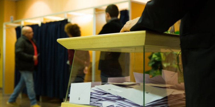 Una urna amb electors de fons a les eleccions del 2015.