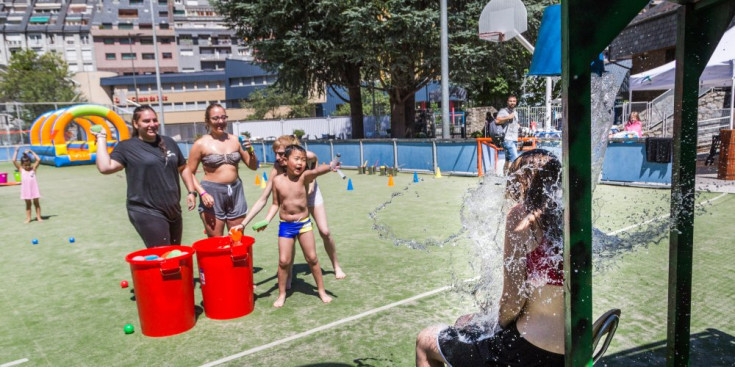 Un grup d’infants es diverteix amb l’aigua a l’Estadi Comunal, ahir.