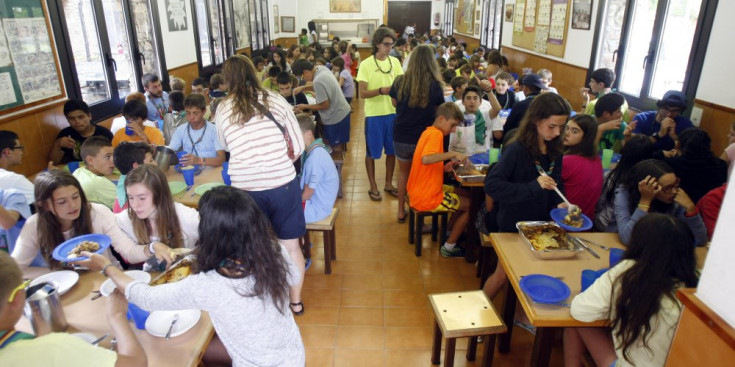 Un grup d’infants i joves dinant en el menjador de la casa de colònies d’AINA.