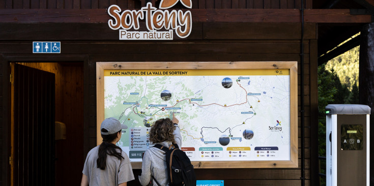 Dues excursionistes consulten el mapa de la vall de Sorteny.