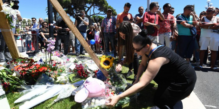 Una dona deixa flors en memòria de les víctimes a Niça, ahir.