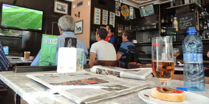 Un grup d’aficionats al futbol segueixen un partit de LaLiga Santander en un bar.
