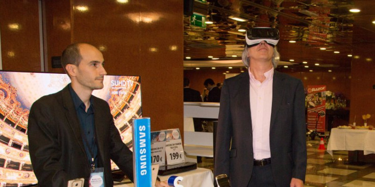 Un home prova unes ulleres de realitat virtual a les quals pots posar-hi el telèfon mòbil.